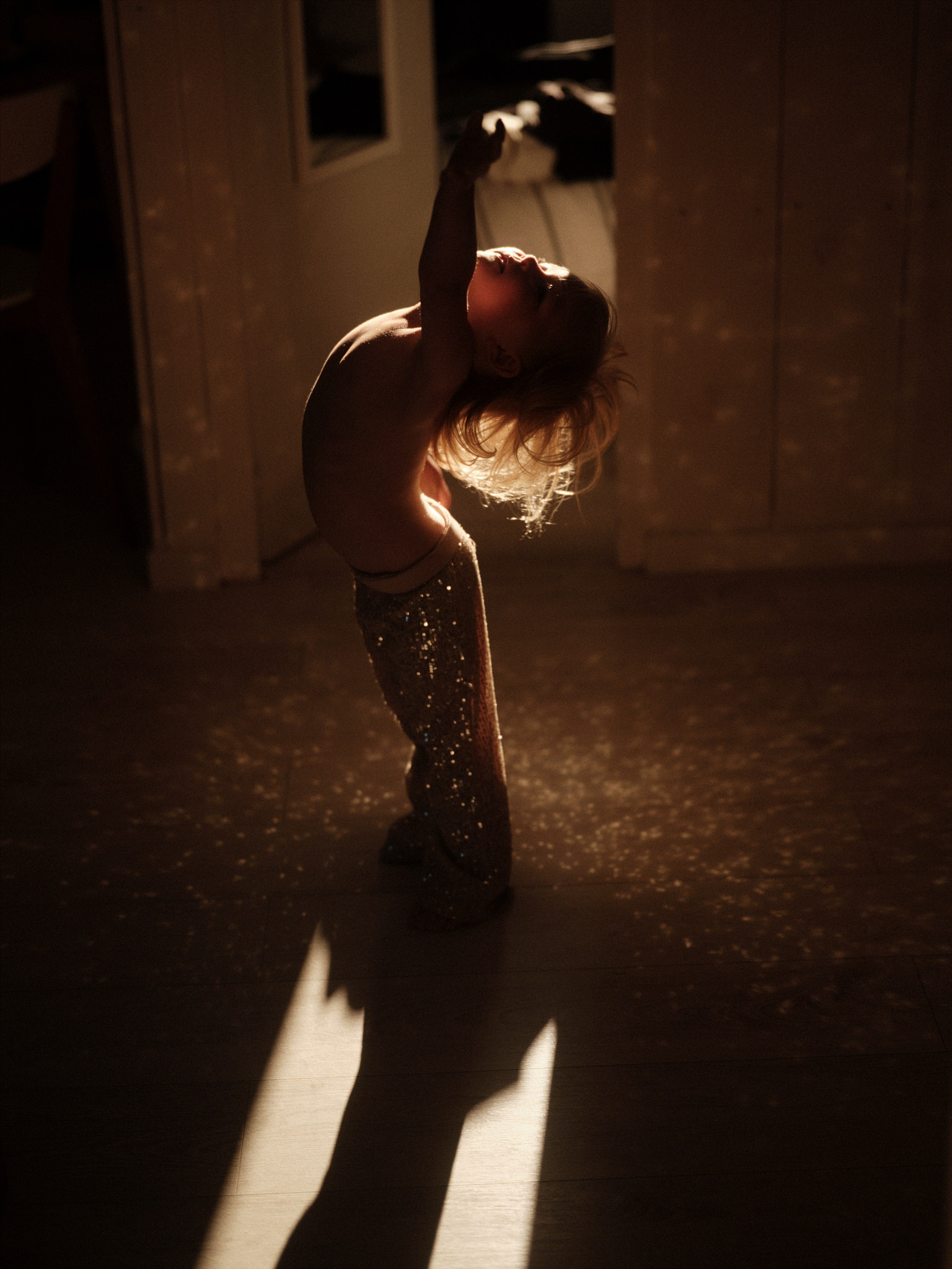 A child standing in low sun casting a long shadow