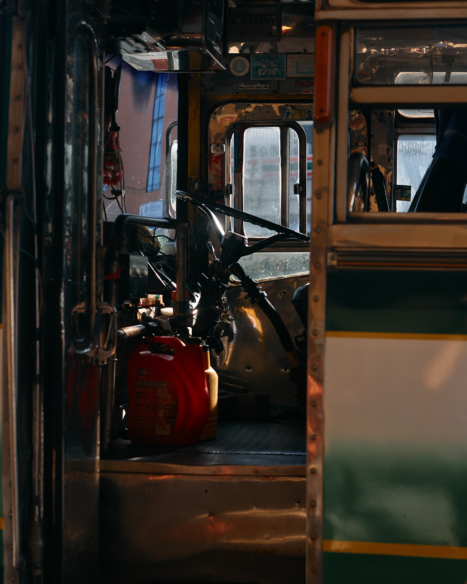Low sun falling into the open doorway of a bus, a red bag on the step