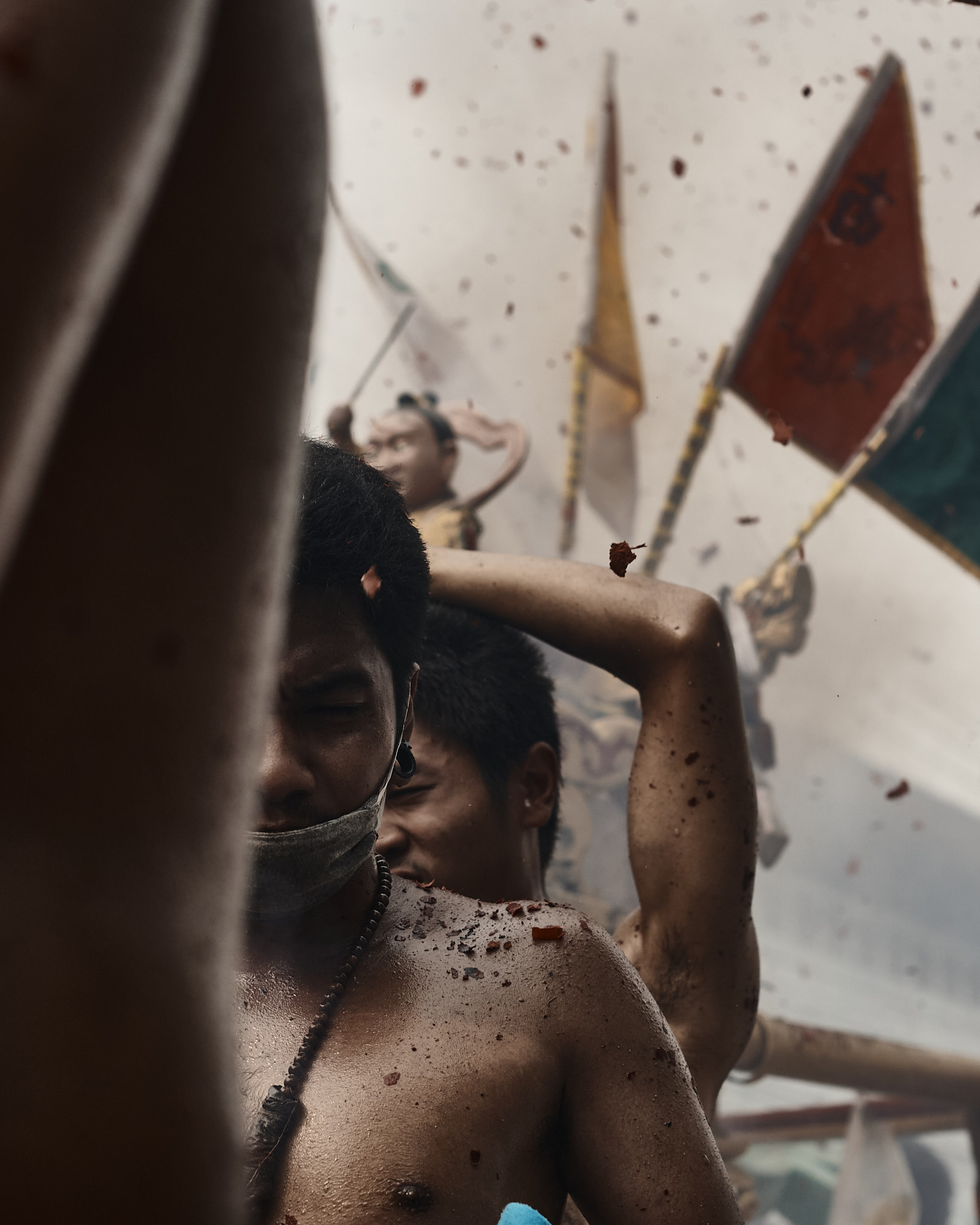 A person carrying a flagged pole as debris falls around them