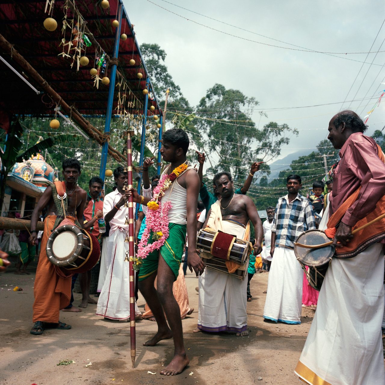 A street procession with drummers and people in ceremonial dress